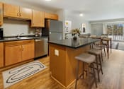 Thumbnail 7 of 32 - A kitchen with wooden cabinets and a black countertop.