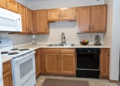 Thumbnail 11 of 34 - a kitchen with white appliances and wooden cabinets  at Briarcliff Apartments, a 55+ Community, Minnesota