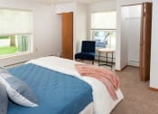 Thumbnail 7 of 34 - a bedroom with a bed and a chair in a room  at Briarcliff Apartments, a 55+ Community, Mahtomedi, MN, 55115