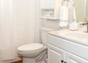 Thumbnail 8 of 34 - a bathroom with a white sink and toilet and a white shower curtain  at Briarcliff Apartments, a 55+ Community, Mahtomedi, 55115