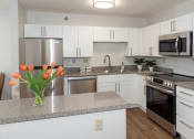 Thumbnail 1 of 34 - a kitchen with white cabinets and gray countertops  at Briarcliff Apartments, a 55+ Community, Mahtomedi