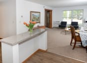 Thumbnail 4 of 34 - a view of the living room and dining area from behind the kitchen counter  at Briarcliff Apartments, a 55+ Community, Mahtomedi, Minnesota