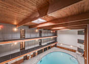 Thumbnail 51 of 56 - a pool in a room with wooden ceilings and white walls