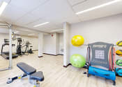 Thumbnail 15 of 28 - a gym with exercise equipment and a yellow ball on the wall