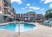 Thumbnail 24 of 34 - A swimming pool in a residential area surrounded by buildings.