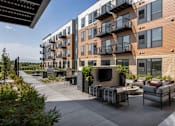 Thumbnail 48 of 61 - A modern outdoor seating area is surrounded by contemporary apartment buildings.