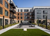 Thumbnail 50 of 61 - A modern building with a grassy area in front.