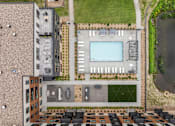 Thumbnail 58 of 61 - A bird's eye view of a building with a pool and parking lot.