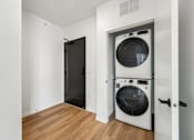 Thumbnail 37 of 61 - A black door is open to a white wall with a washer and dryer in the other room.