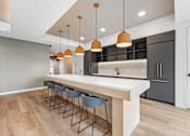 Thumbnail 6 of 61 - A modern kitchen with a long island and bar stools.