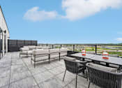 Thumbnail 16 of 61 - A patio with a table and chairs overlooking a field.