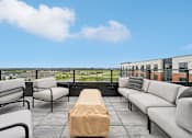 Thumbnail 17 of 61 - A patio with a table and chairs overlooking a cityscape.
