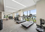 Thumbnail 21 of 61 - A gym with treadmills, exercise bikes, and other equipment.