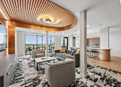 Thumbnail 2 of 61 - A modern living room with a curved wooden ceiling and a large grey sofa.