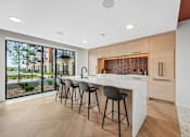 Thumbnail 5 of 61 - A modern kitchen with a bar area and a view of the outdoors.
