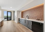 Thumbnail 11 of 61 - A modern kitchen with a dark brown backsplash and wooden floors.