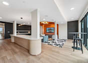 Thumbnail 10 of 61 - A modern interior with a reception desk and a bar area.