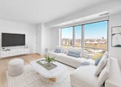 Thumbnail 33 of 61 - A modern living room with a large window overlooking a cityscape.