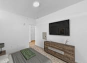 Thumbnail 45 of 61 - A modern bedroom with a bed, a nightstand, and a television.