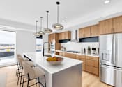 Thumbnail 27 of 61 - A modern kitchen with a large island and stainless steel appliances.