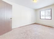 Thumbnail 33 of 56 - a bedroom with white walls and carpet