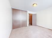 Thumbnail 17 of 56 - a bedroom with white walls and a sliding door to a closet