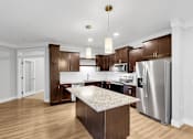 Thumbnail 21 of 47 - A modern kitchen with wooden cabinets and stainless steel appliances.