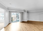 Thumbnail 22 of 47 - A spacious room with wooden floors and white walls.