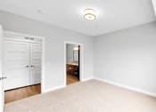 Thumbnail 16 of 47 - A white bedroom with a door and a window.