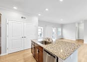 Thumbnail 8 of 47 - A kitchen with a granite countertop and stainless steel appliances.