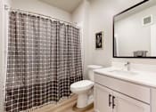 Thumbnail 66 of 67 - A bathroom with a checkered shower curtain and a white toilet.