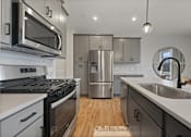 Thumbnail 20 of 48 - a kitchen with stainless steel appliances and white counter tops at Foxtail Hollow Townhomes, Minnesota, 55449