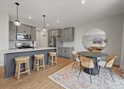 Thumbnail 18 of 48 - a kitchen and dining area with a round table and stools at Foxtail Hollow Townhomes, Minnesota, 55449