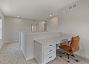 Thumbnail 25 of 48 - a white office with a desk and a chair at Foxtail Hollow Townhomes, Blaine