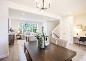 Thumbnail 7 of 48 - a living room and dining room with a wooden table and chairs at Foxtail Hollow Townhomes, Blaine, MN