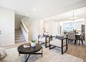 Thumbnail 8 of 48 - a living room with a table and chairs and a staircase at Foxtail Hollow Townhomes, Blaine, MN
