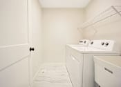 Thumbnail 15 of 15 - A small laundry room with a washer and dryer.
