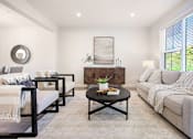 Thumbnail 4 of 15 - A living room with a grey couch, a coffee table, and a painting on the wall.