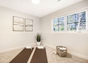 Thumbnail 12 of 15 - A room with a yoga mat, a potted plant, and a basket on the floor.