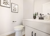 Thumbnail 13 of 15 - A white toilet sits in a bathroom next to a sink.