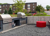 Thumbnail 7 of 40 - an outdoor kitchen with a red stool in front of a brick building