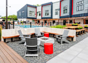 Thumbnail 8 of 40 - a seating area with tables and chairs in front of a row of buildings