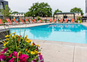 Thumbnail 2 of 40 - a swimming pool with chairs and flowers around it