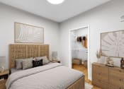 Thumbnail 102 of 110 - A bedroom with a large bed, a nightstand, and a dresser with a mirror.