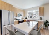 Thumbnail 35 of 52 - A modern kitchen with a dining table and chairs.