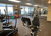 Thumbnail 24 of 35 - Fitness center with large windows and mirrors at Aspenwood Apartments, Eagan, MN