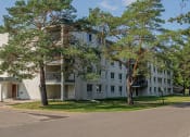 Thumbnail 35 of 38 - a large white apartment building with trees in front of it