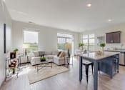 Thumbnail 6 of 82 - A modern kitchen and living room with a large island and dark wood floors. at Lake Jonathan Flats, Chaska