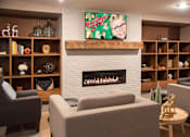 Thumbnail 46 of 60 - Community room with comfortable seating, tv and fireplace at The McMillan.
