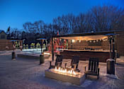Thumbnail 8 of 60 - Outdoor patio with firepit, bar, and seating in the winter time at The McMillan